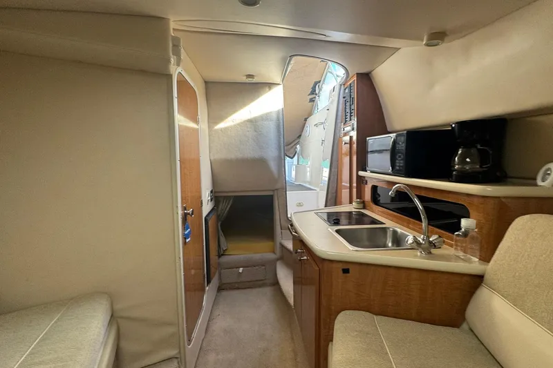Slide: The Image of 2003 Maxum 2400 SCR boat interior with kitchenette, sink, and seating area. - 24
