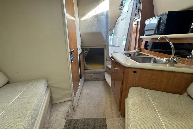 Slide: The Image of Interior of 2003 Maxum 2400 SCR boat with kitchenette and seating area. - 25
