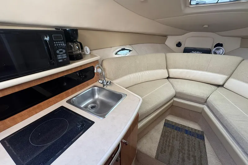 Slide: The Image of 2003 Maxum 2400 SCR boat interior with kitchenette and cozy seating area. - 26