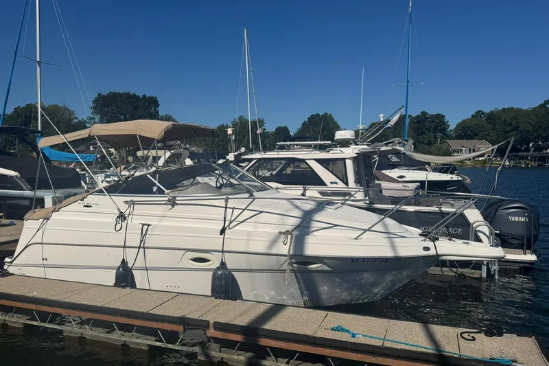 Slide: The Image of 2003 Maxum 2400 SCR boat docked at marina, white hull, sleek design. - 3