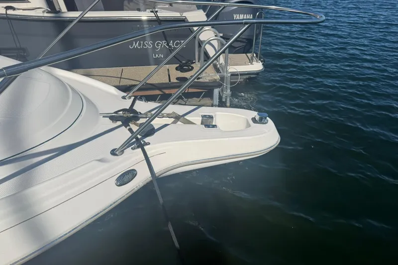 Slide: The Image of 2003 Maxum 2400 SCR boat with canopy, docked at marina, featuring seating and table. - 5