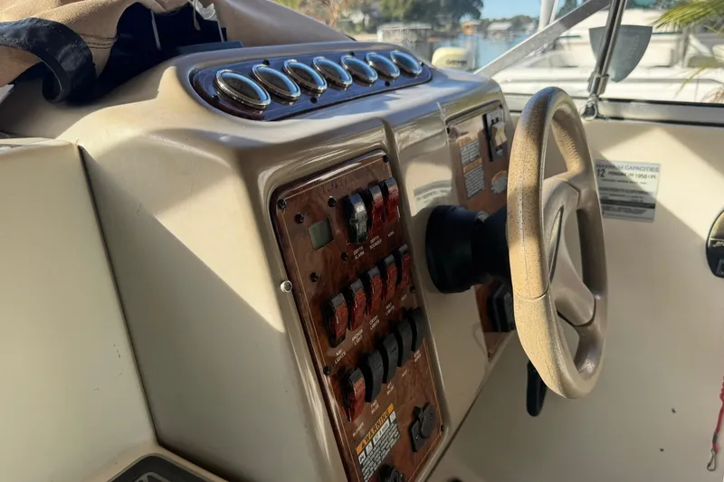 Slide: The Image of 2003 Maxum 2400 SCR boat interior with white seating and wooden table. - 9