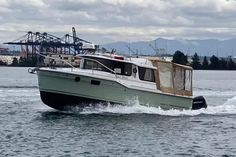 The Image of 2018 Ranger Tugs R-23 cruising on a cloudy day near industrial docks. - 0