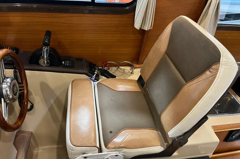Slide: The Image of Captain's seat and controls of a 2017 Ranger Tugs R-23 boat interior. - 13
