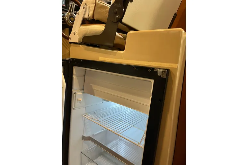 Slide: The Image of Open refrigerator inside 2017 Ranger Tugs R-23 boat, showcasing interior shelves. - 14