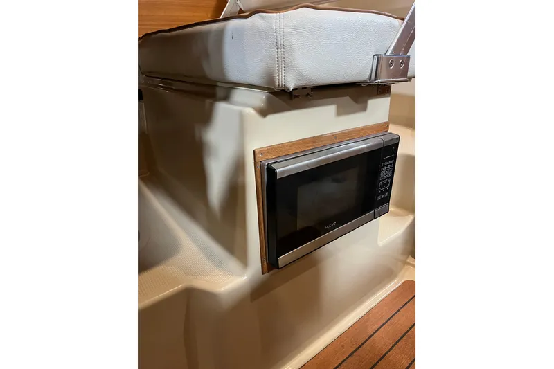 Slide: The Image of Microwave installed in 2017 Ranger Tugs R-23 boat interior, featuring wood accents. - 16