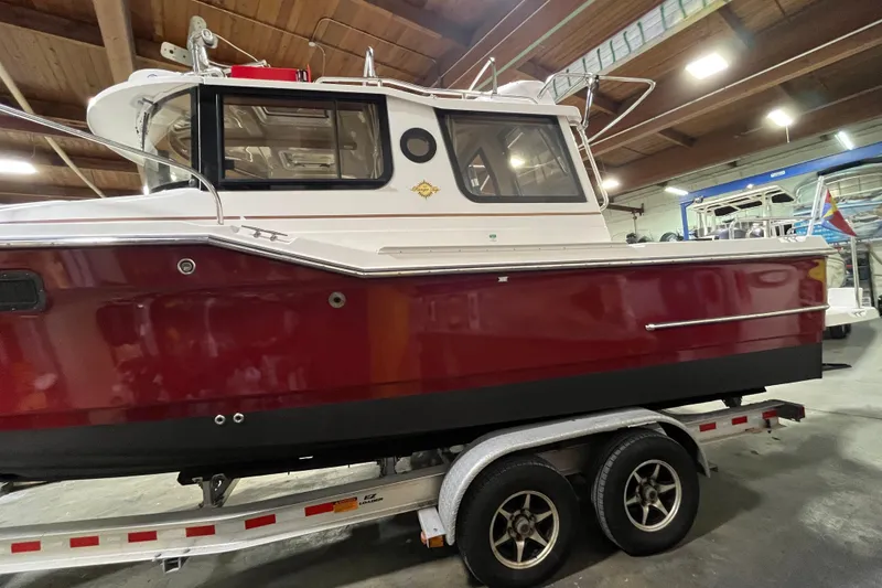 Slide: The Image of 2017 Ranger Tugs R-23 boat with red hull on a trailer in a warehouse. - 6