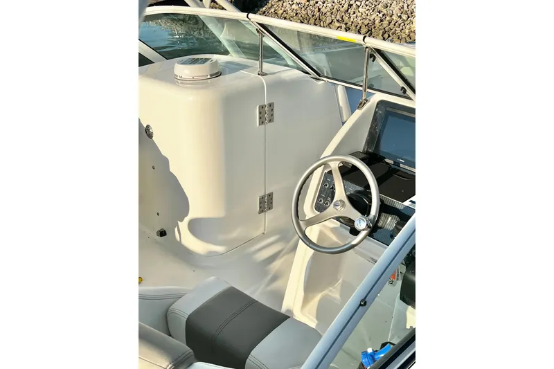 Slide: The Image of 2022 World Cat 230 DC boat interior with steering wheel and dashboard. - 13