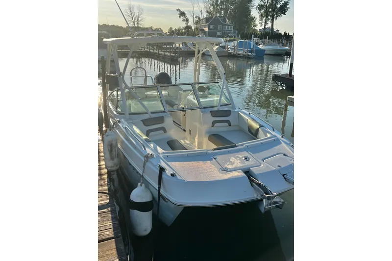 Slide: The Image of 2022 World Cat 230 DC boat docked at a serene marina during sunset. - 5