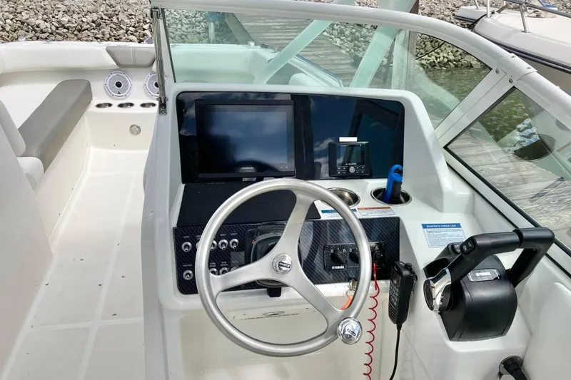 Slide: The Image of 2022 World Cat 230 DC boat dashboard with steering wheel and navigation screens. - 7