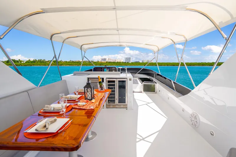 Slide: The Image of Luxurious 1991 Maiora Planning yacht deck with elegant dining setup, overlooking serene blue waters. - 23