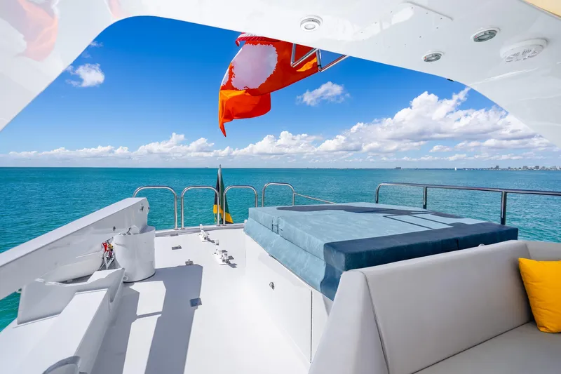 Slide: The Image of Luxurious 1991 Maiora Planning yacht deck with ocean view, featuring comfortable seating and vibrant flags. - 25