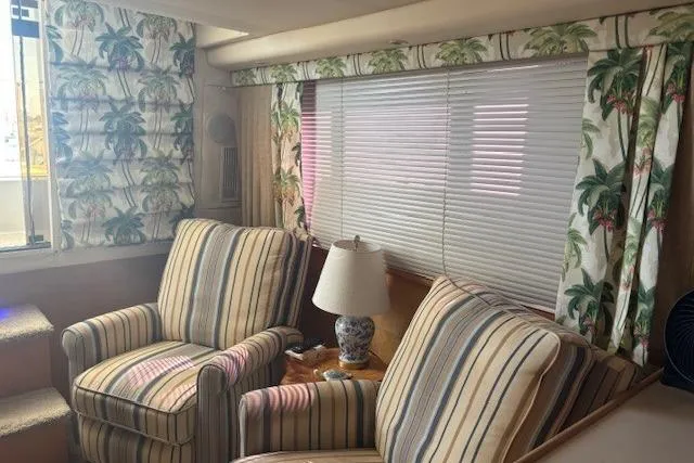 Slide: The Image of Interior of 1996 Carver 355 Aft Cabin Motor Yacht with striped chairs and tropical curtains. - 10