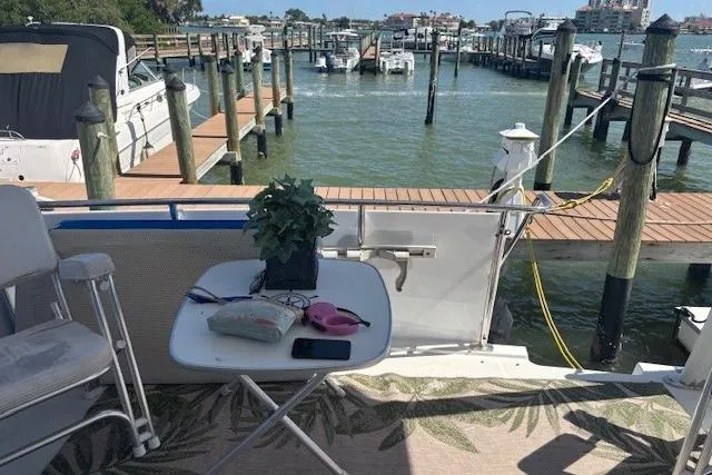 Slide: The Image of 1996 Carver 355 Aft Cabin Motor Yacht docked, with table and chairs on deck. - 8