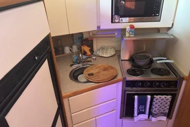 Slide: The Image of Compact kitchen in 1996 Carver 355 Aft Cabin Motor Yacht with stove, sink, and microwave. - 12