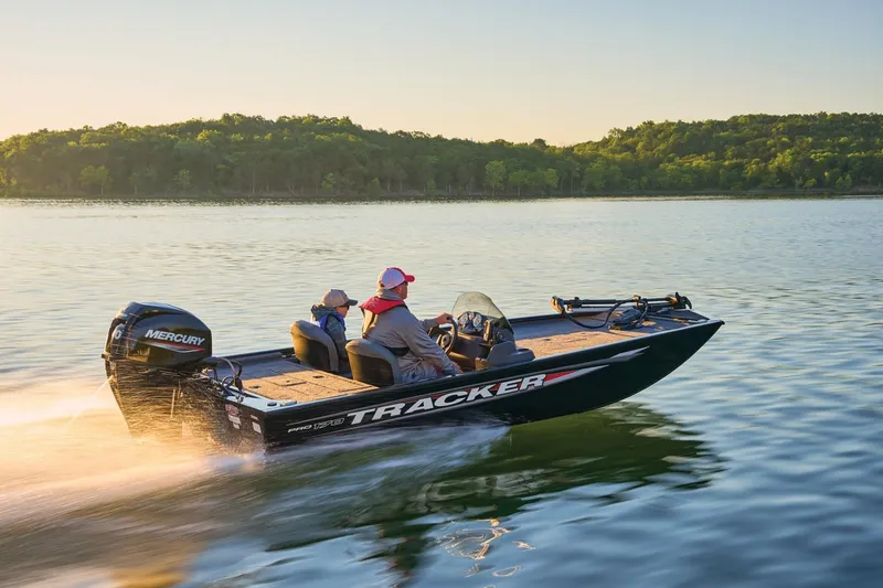 Slide: The Image of 2026 Tracker Pro 170 boat cruising on a serene lake at sunset. - 13