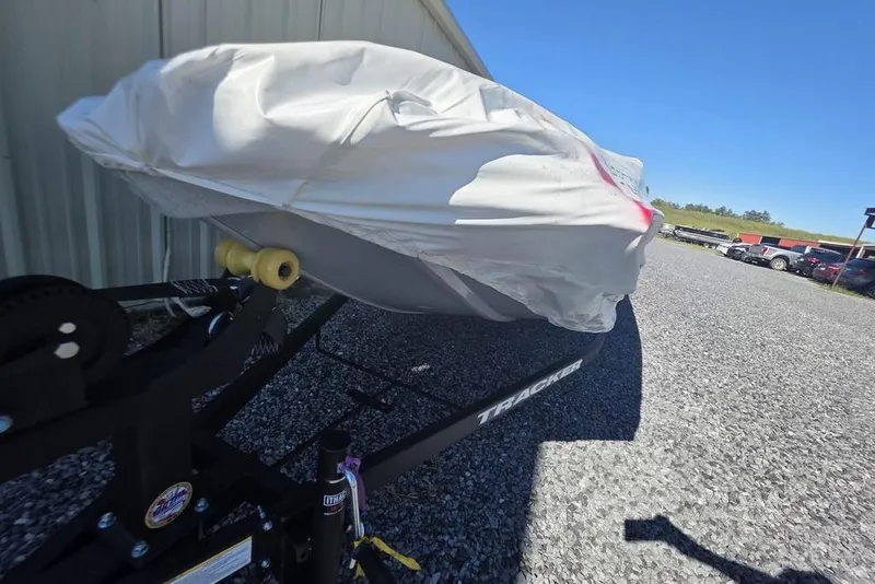 Slide: The Image of Covered 2026 Tracker Pro 170 boat on trailer, parked on gravel near a building. - 8
