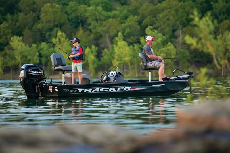 Slide: The Image of Two people fishing on a 2026 Tracker Pro 170 boat in a serene lake. - 9