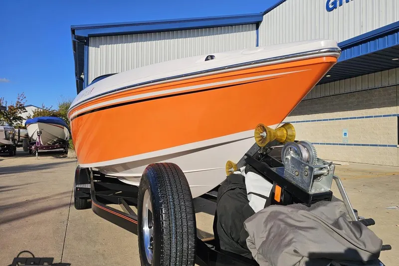 Slide: The Image of 2016 Baja 247 Islander boat with orange hull on trailer, parked outside a building. - 13