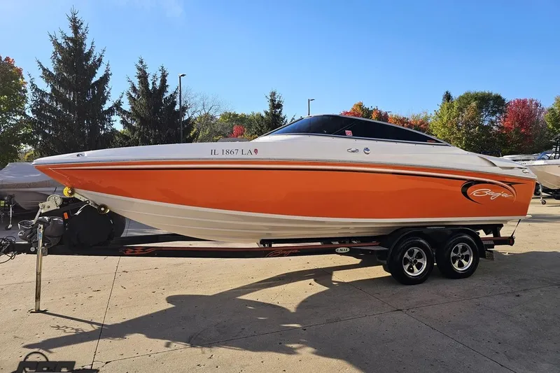 Slide: The Image of 2016 Baja 247 Islander boat on trailer, vibrant orange and white design, parked outdoors. - 18