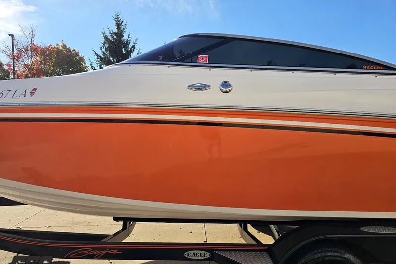 Slide: The Image of 2016 Baja 247 Islander boat with orange and white exterior on a trailer. - 20