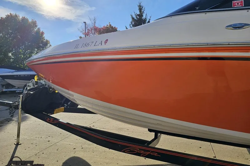 Slide: The Image of 2016 Baja 247 Islander boat with orange hull on a trailer, sunny day. - 21