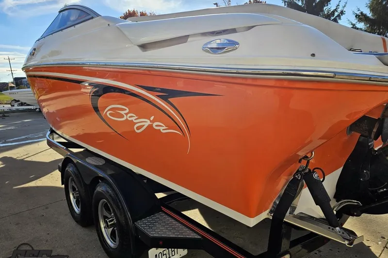 Slide: The Image of 2016 Baja 247 Islander boat with orange and white design on a trailer. - 26