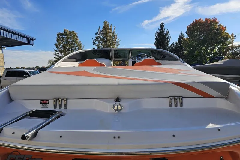 Slide: The Image of 2016 Baja 247 Islander boat with orange accents, rear view under clear blue sky. - 32