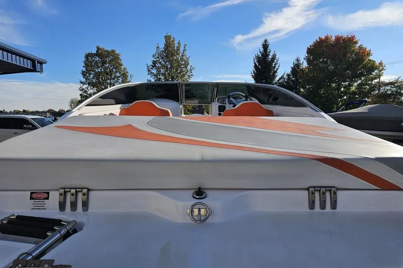 Slide: The Image of 2016 Baja 247 Islander boat with orange and white seating, parked outdoors. - 33