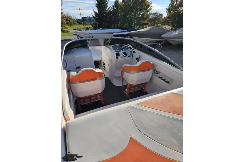 Slide: The Image of 2016 Baja 247 Islander boat interior with orange and white seating, steering wheel, and dashboard. - 36