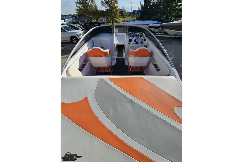 Slide: The Image of 2016 Baja 247 Islander boat interior with orange and gray seating, parked outdoors. - 37