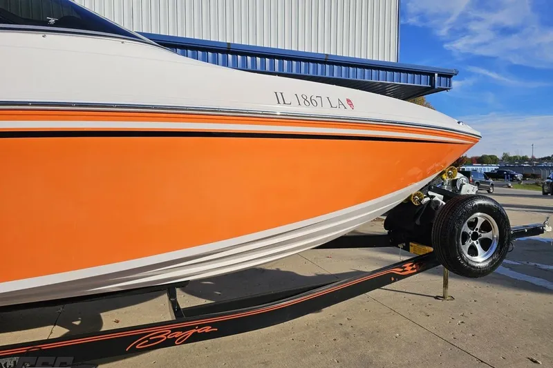 Slide: The Image of 2016 Baja 247 Islander boat with orange hull on trailer, parked outdoors. - 4