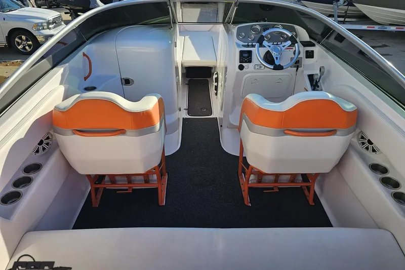 Slide: The Image of 2016 Baja 247 Islander boat interior with orange and white seating, steering wheel, and cup holders. - 42