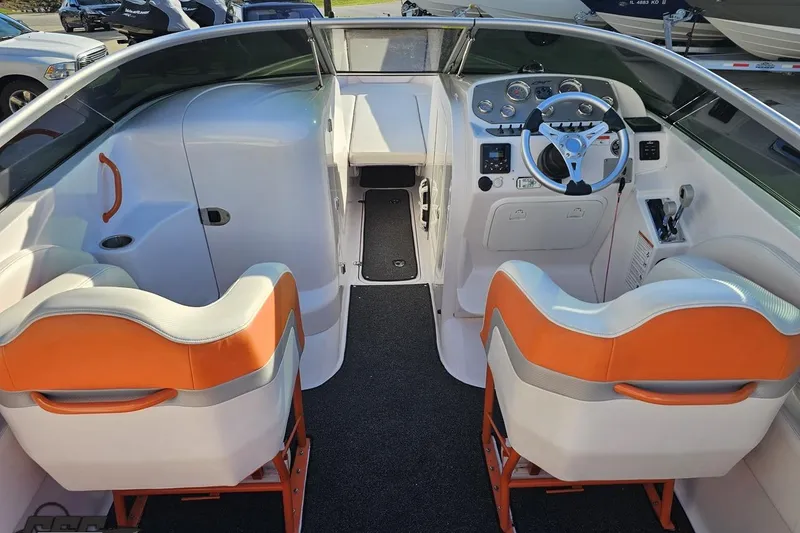 Slide: The Image of 2016 Baja 247 Islander boat interior with orange and white seating, steering wheel, and dashboard controls. - 43