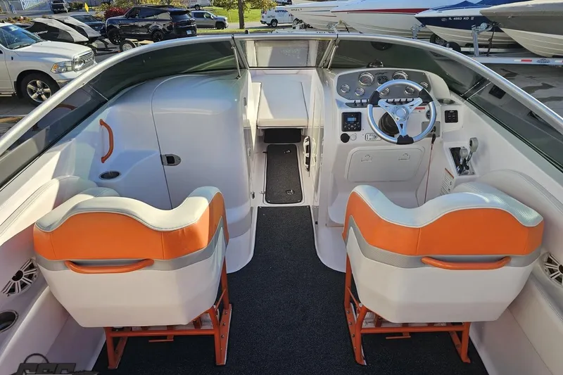 Slide: The Image of 2016 Baja 247 Islander boat interior with orange and white seating, steering wheel, and dashboard. - 44