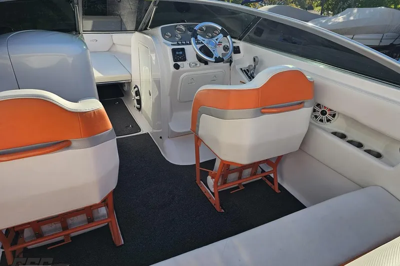 Slide: The Image of 2016 Baja 247 Islander boat interior with orange and white seating, steering wheel, and dashboard. - 47