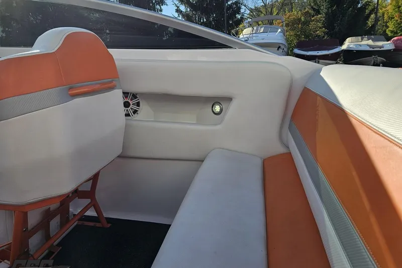Slide: The Image of Interior of a 2016 Baja 247 Islander boat with orange and white seating. - 50