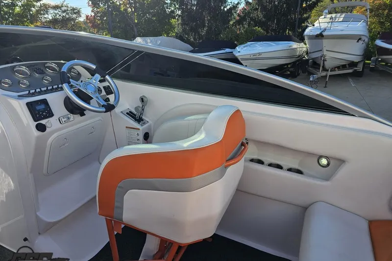 Slide: The Image of 2016 Baja 247 Islander boat interior with orange and white seating, steering wheel, and control panel. - 51