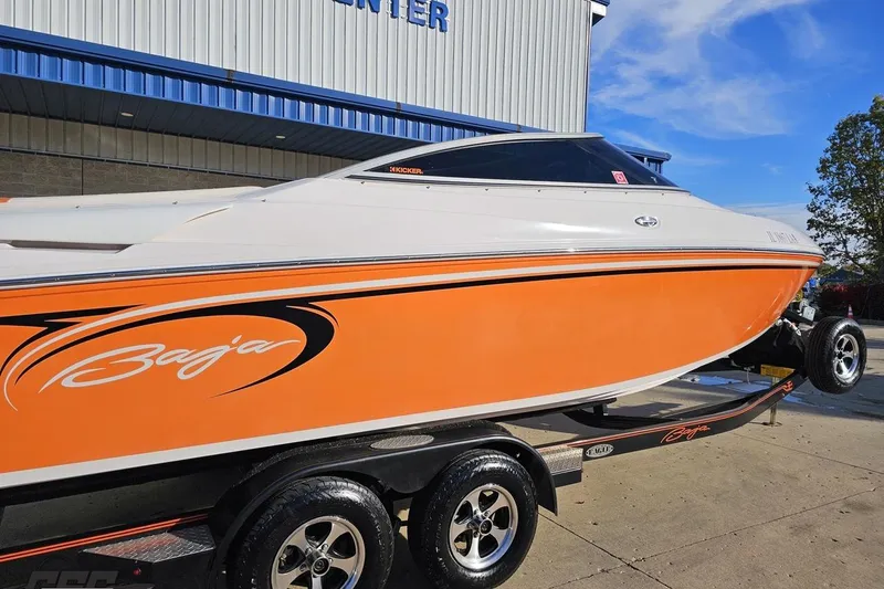 Slide: The Image of 2016 Baja 247 Islander boat with orange and white design on a trailer. - 7