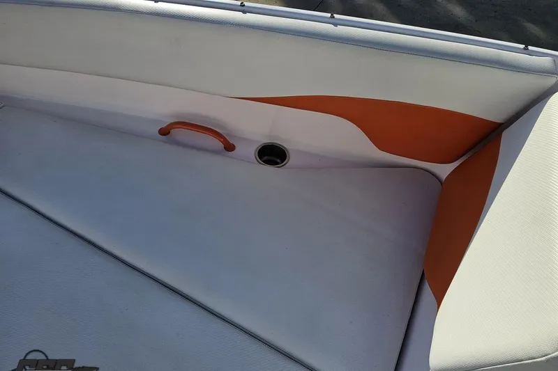 Slide: The Image of Interior seating of a 2016 Baja 247 Islander boat with orange and white upholstery. - 77