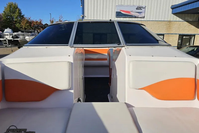 Slide: The Image of 2016 Baja 247 Islander boat with orange and white interior, docked near a building. - 83