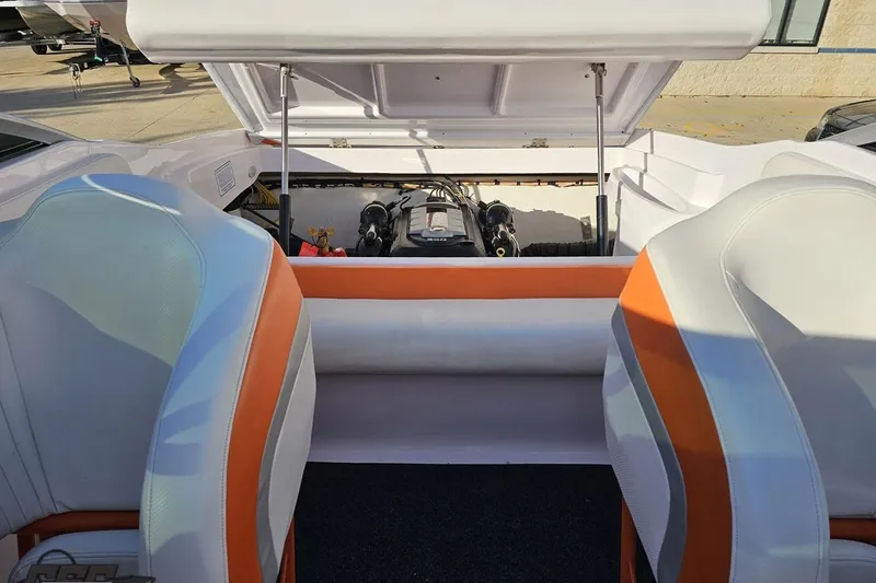 Slide: The Image of 2016 Baja 247 Islander boat interior with open engine compartment, featuring orange and white seating. - 93