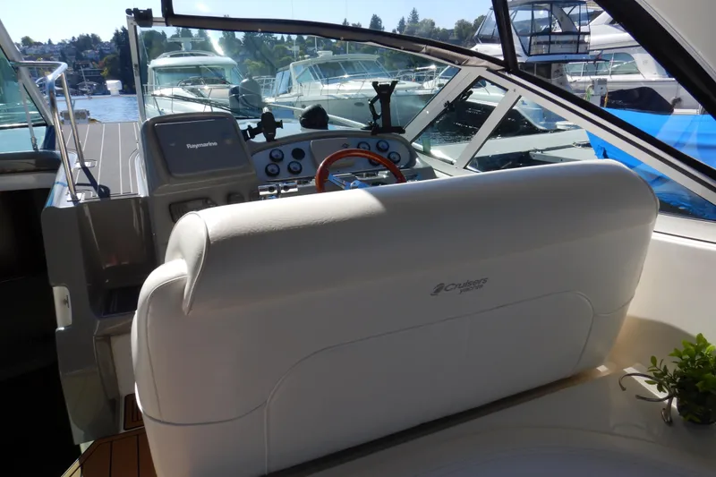 Slide: The Image of 2007 Cruisers 340 Express boat interior with white seating and wooden flooring. - 13