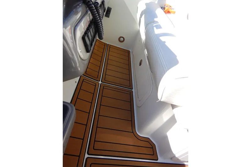 Slide: The Image of 2007 Cruisers 340 Express boat interior seating with white upholstery and wooden flooring. - 15