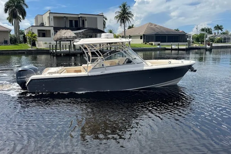 Slide: The Image of 2020 Grady-White Freedom 285 boat on a calm waterfront, modern homes in the background. - 11