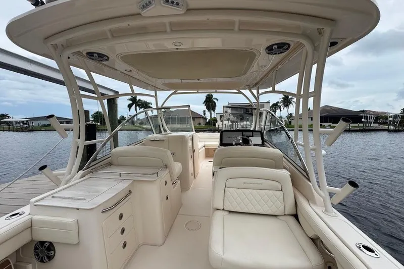 Slide: The Image of 2020 Grady-White Freedom 285 boat interior with seating and helm, docked by waterfront homes. - 14