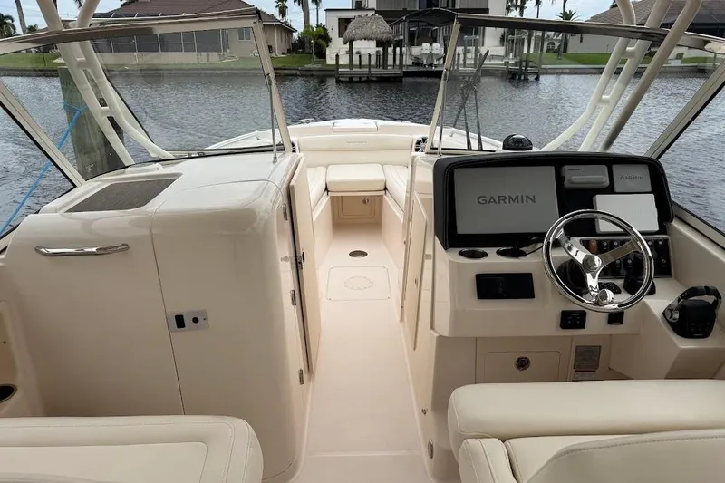 Slide: The Image of 2020 Grady-White Freedom 285 boat interior with Garmin navigation system, docked by waterfront homes. - 28