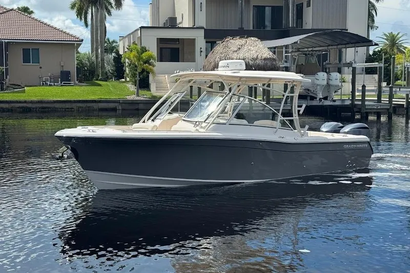 Slide: The Image of 2020 Grady-White Freedom 285 boat on calm water near waterfront homes. - 3