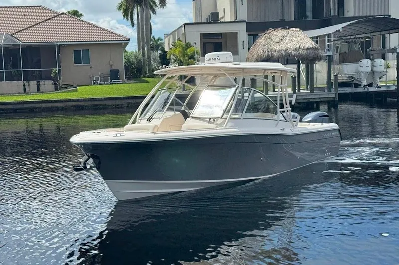 Slide: The Image of 2020 Grady-White Freedom 285 boat cruising on a calm waterfront near residential homes. - 4