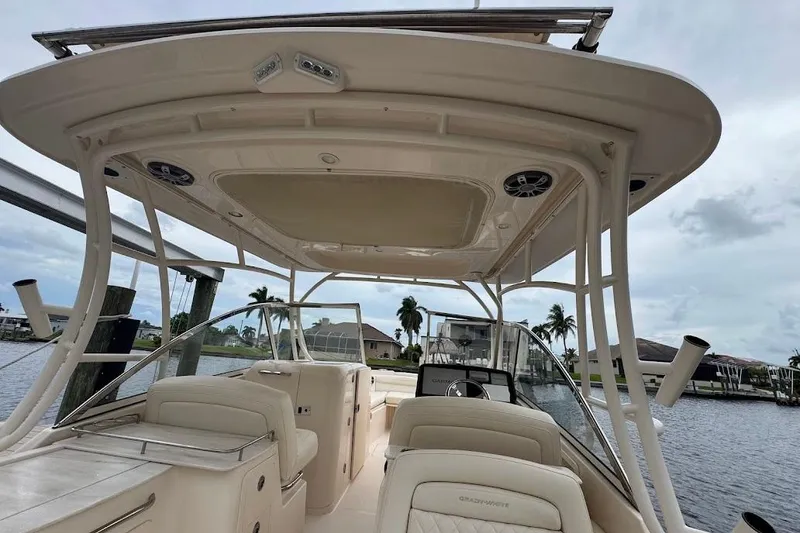 Slide: The Image of 2020 Grady-White Freedom 285 boat interior with seating and canopy, docked by waterfront homes. - 45